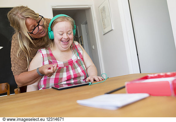 Mother and daughter with syndrome using digital tablet