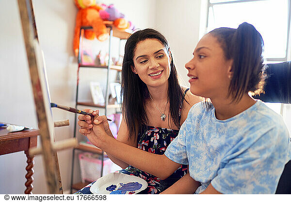 Mother and disabled daughter painting at home