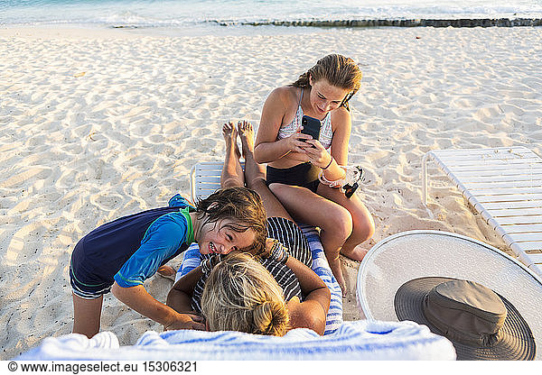 Mother and her children enjoying the beach at sunset