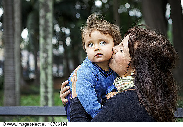 mother and little boy cuddling in the park