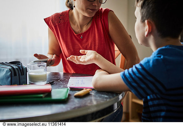 Mother and son at dining table having discussion