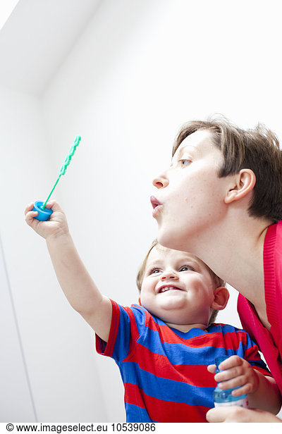 Mother and son blowing bubbles together