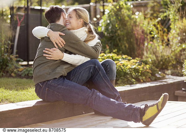 Mother and son embracing while sitting in garden