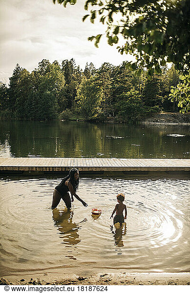 Mother and son playing in lake during vacation