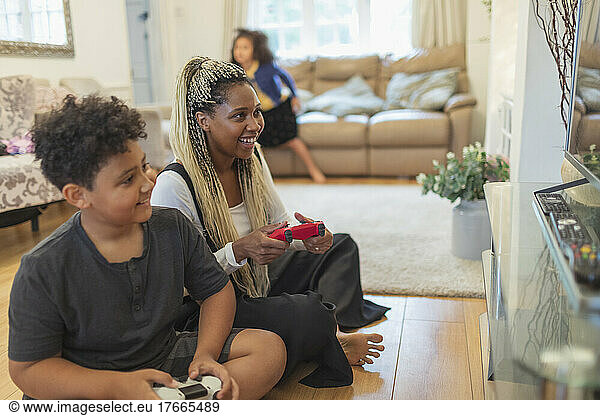 Mother and son playing video game on living room floor