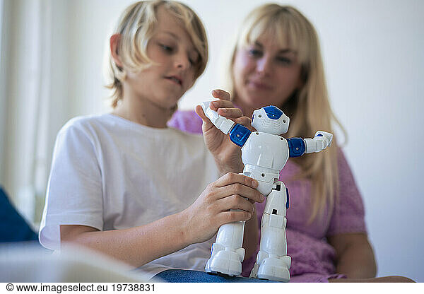 Mother and son playing with robot at home