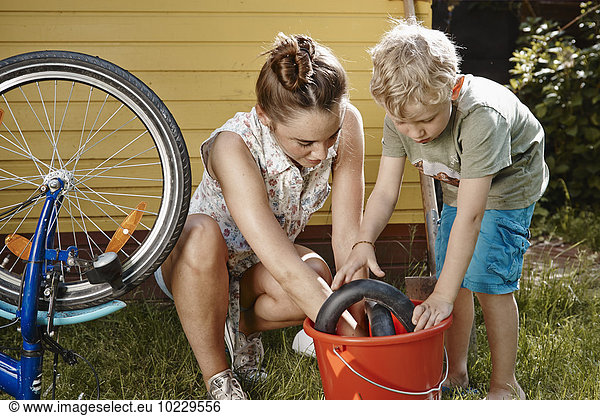 Mother and son repairing bicycle together