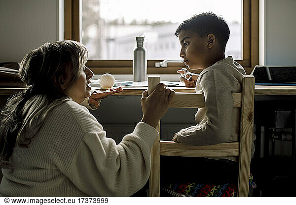 Mother and son talking with each other at home