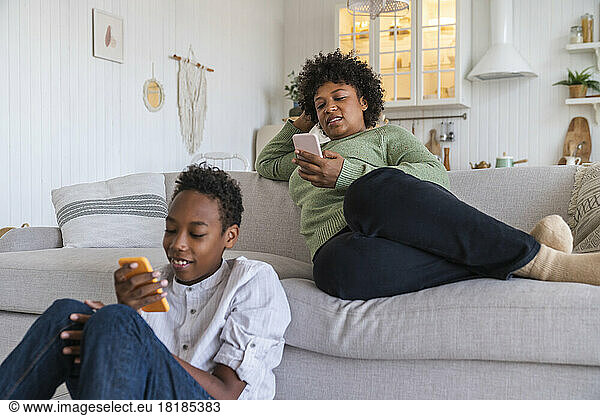 Mother and son using smart phones at home