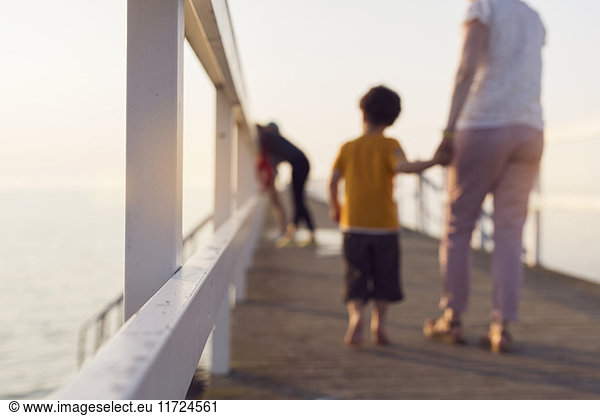 Mother and son (4-5) walking on pier  holding hands