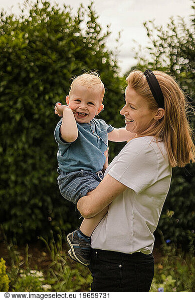 Mother and toddler share joyful playtime in the garden