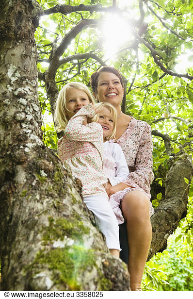 Mother and two daughters sitting tree