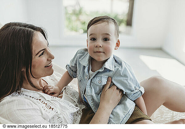 Mother and young son swinging in hammock in natural light studio
