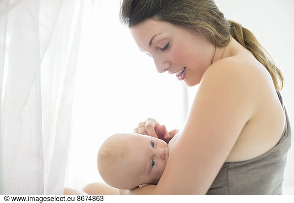 Mother breast-feeding baby girl