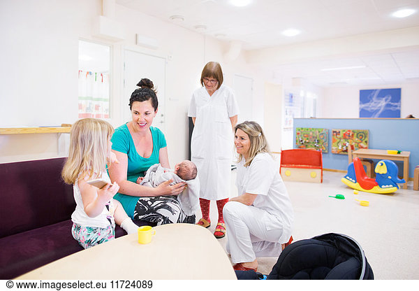 Mother  children (0-1 months  2-3)  nurse and doctor in waiting room