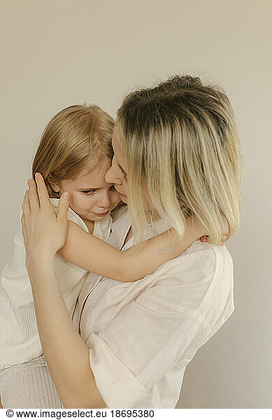 Mother consoling sad daughter at home
