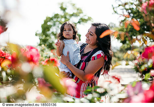 Mother & Daughter Smiling in Rose Garden