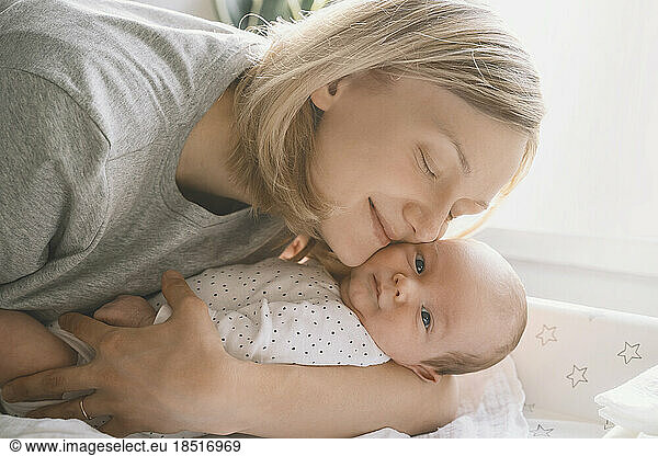 Mother embracing baby boy at home