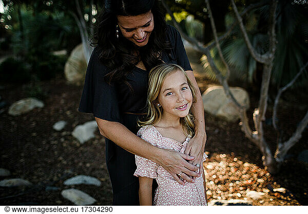 Mother Embracing Young Daughter in Garden in San Diego
