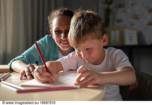 Mother helping son to draw