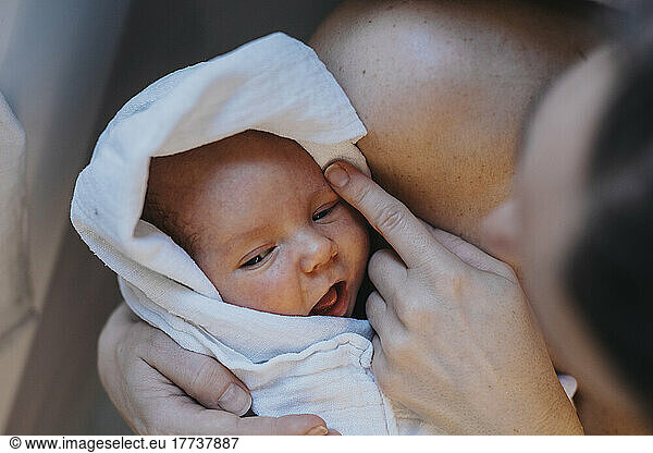 Mother holding baby wrapped in towel