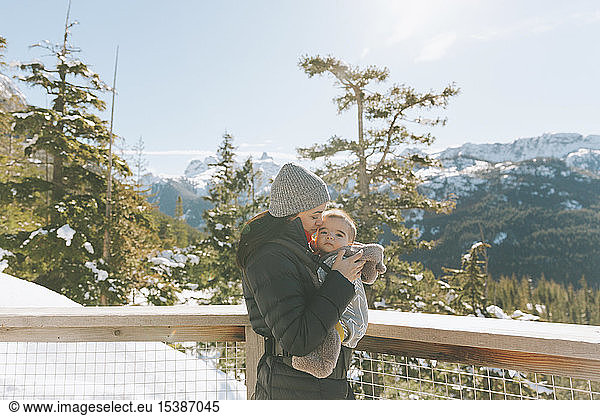 Mother holding her baby son on an observation deck  looking over Squamish  Canada