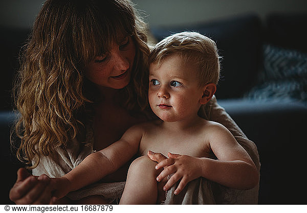 Mother hugging his child at home showing skin