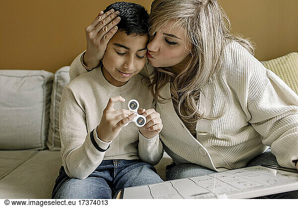 Mother kissing son while teaching at home