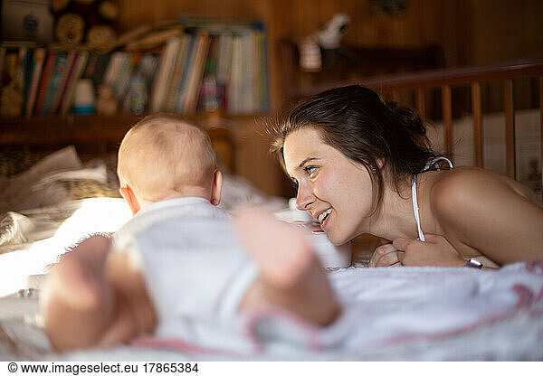 Mother lovingly looks at her baby in a cozy room
