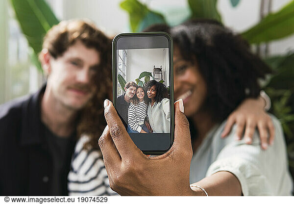 Mother proudly displays family selfie on smartphone