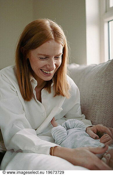 Mother smiles lovingly at her newborn baby  pure joy