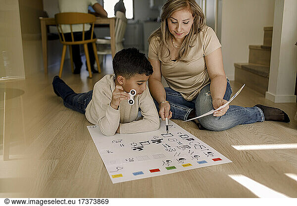 Mother teaching autistic son while sitting in living room