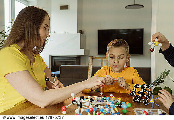 Mother teaching boy about molecules at home