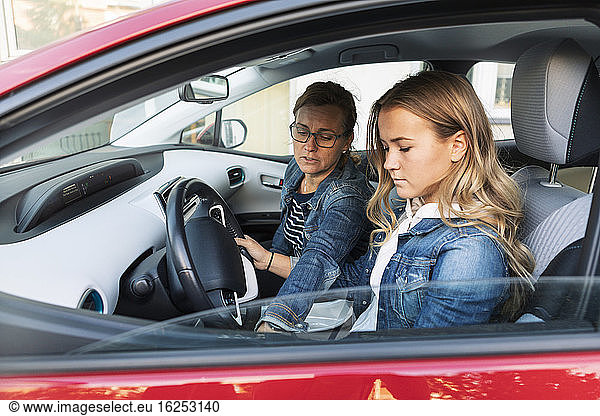 Mother teaching daughter driving during weekend