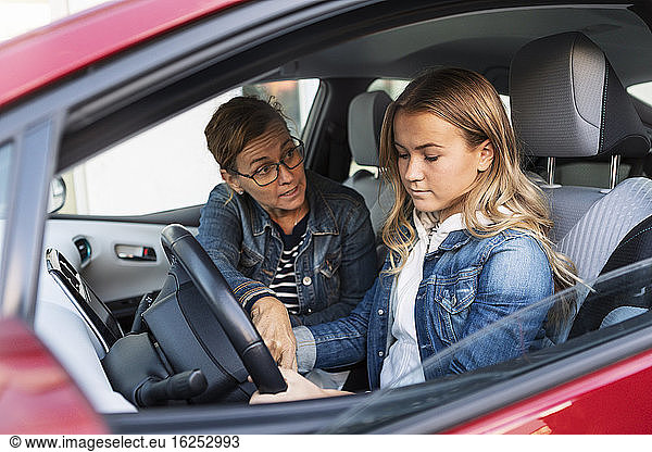 Mother teaching teenager driving during weekend