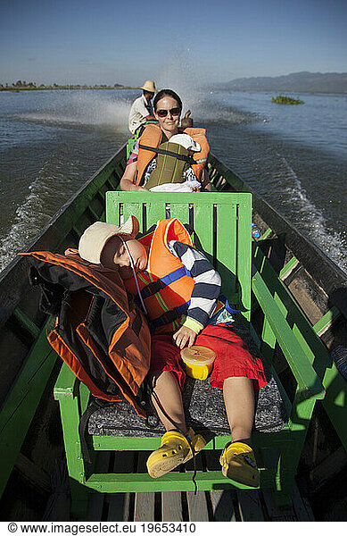 Mother travelling with 2 young boys by boat on Inle Lake  Myanmar.