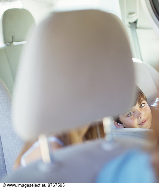 Mother turning to talk to children in back seat of car