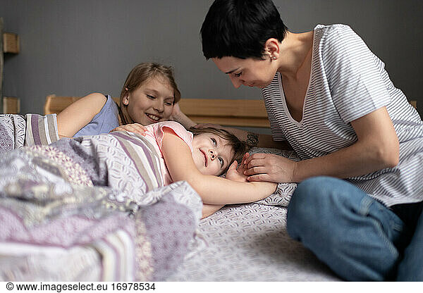 Mother waking up daughters in morning