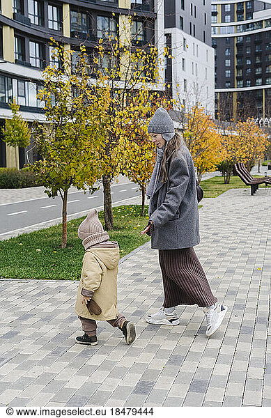 Mother walking with son on footpath