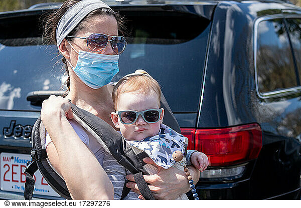 Mother wearing mask holding her baby boy.