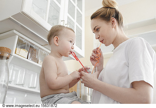 Mother with her little boy drinking a glass of juice