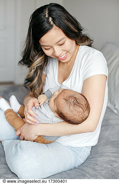 Mothers day holiday. Proud Chinese Asian mother holding newborn baby.