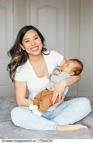 Mothers day holiday. Proud smiling Asian mother with newborn baby boy