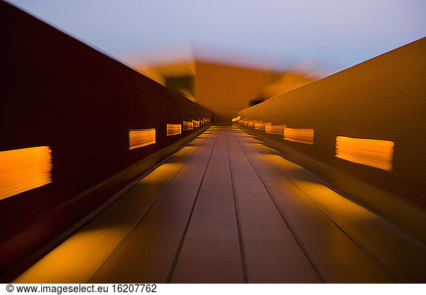 Motion blur  a colorful walkway with balustrade and patches of sunlight.