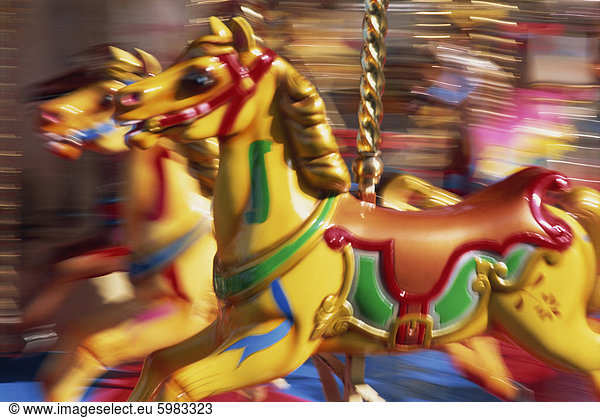 Motion blur of brightly painted merry go round (carousel) horses at speed  Skegness  Lincolnshire  England  United Kingdom  Europe