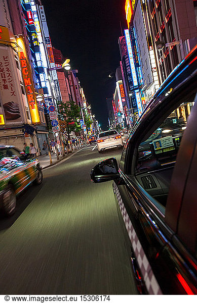 Motion blurred view from taxi of street and neon advertising signs at night in Shinjuku District  Tokyo  Japan.