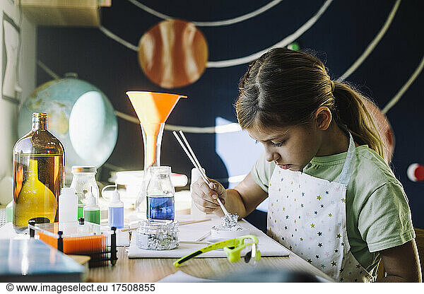 Motivated female scientist doing experiment at table