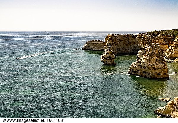Motorboote kreisen an der felsigen Küste in Praia da Marinha  Algarve  Portugal