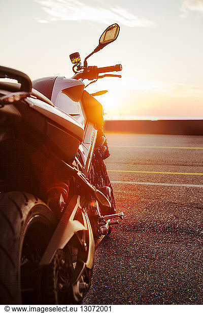 Motorcycle on coastal road during sunset
