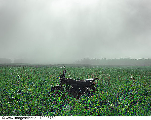Motorrad bei nebligem Wetter auf Grasfeld geparkt